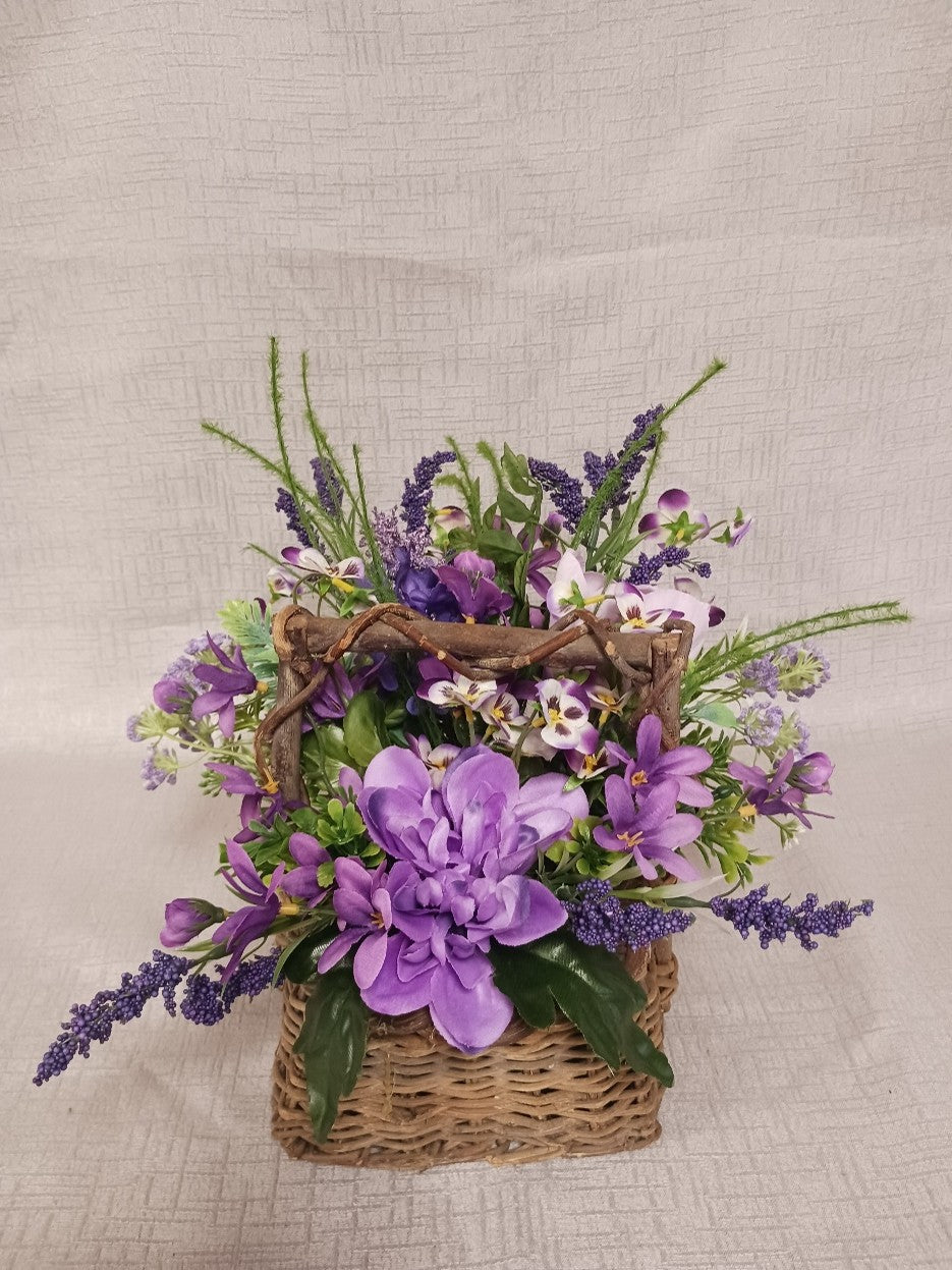 Purple flowers in a brown wicker basket
